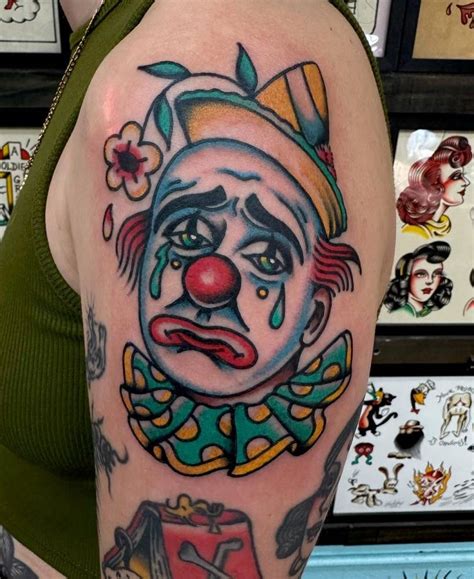 Traditional style sad clown tattoo located on the upper