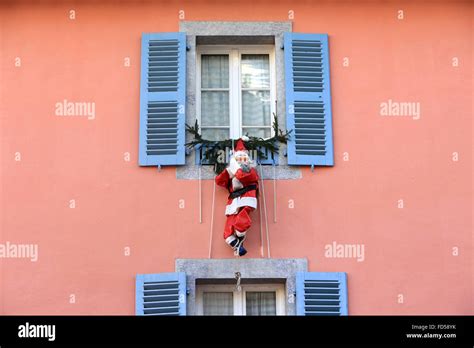 Santa Claus hanging from a window Stock Photo - Alamy