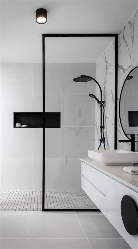 a bathroom with white tile and black accents