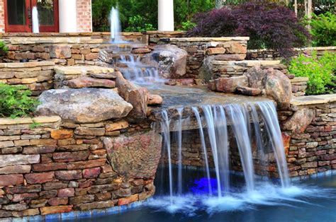 This pool's stacked stone waterfall and fountains provide both visual ...