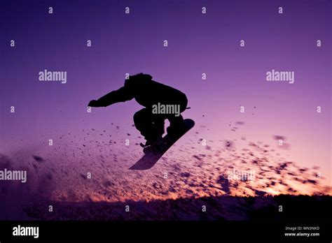 Silhouette snowboarder flying at sunset sky background. Soft focus ...