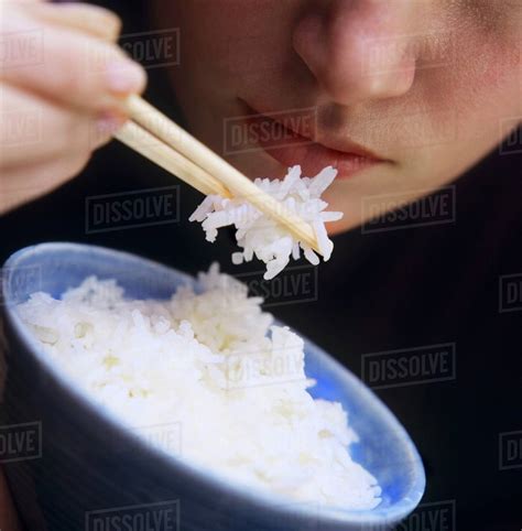 A Person Eating Rice with Chopsticks - Stock Photo - Dissolve