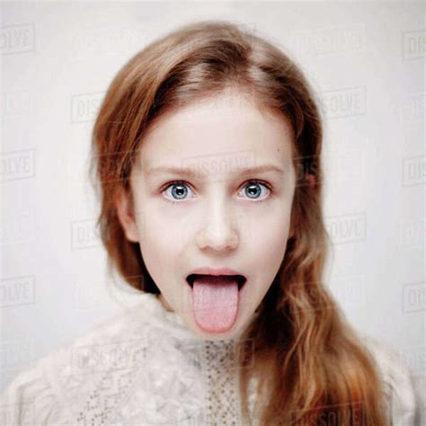 Caucasian teenage girl sticking out tongue - Stock Photo - Dissolve