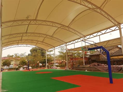 Basketball court shade canopy has a cable-tensioned fabric roof and ...