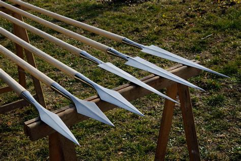 several wooden arrows are lined up on the ground