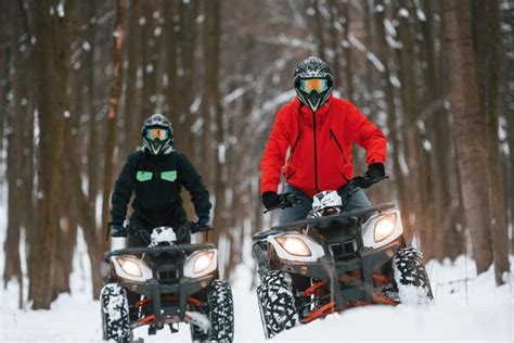 Premium Photo | Front view two people are riding atv in the winter forest