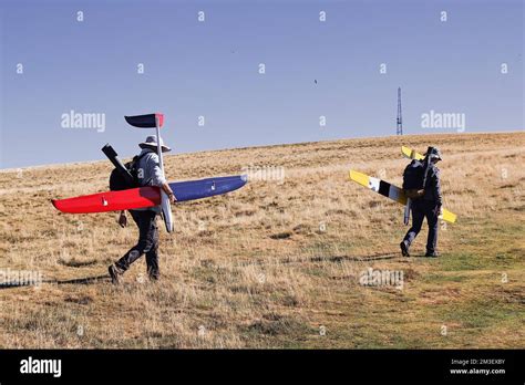 Men climb to the top of hill to launch a radio-controlled glider model ...