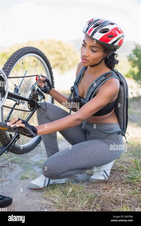 Fit woman fixing the chain on her bike Stock Photo - Alamy