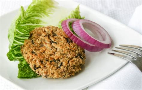 a close up of a plate of food with lettuce and a burger on it