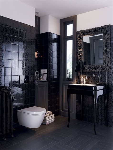 The sleek, detailed, black tile walls make for a powder room that is ...