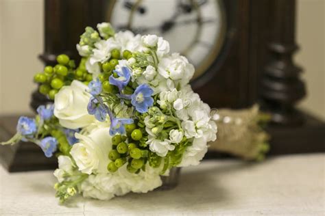 White Roses and Periwinkle Wedding Bouquet Set on a Table Stock Photo ...