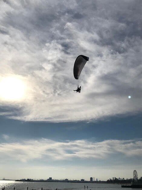 Premium Photo | Person paragliding flying against sky