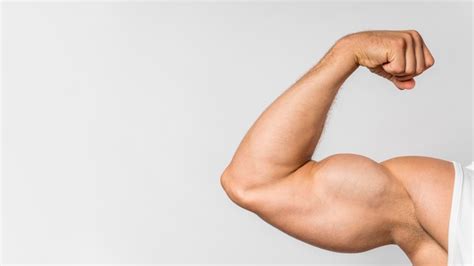 Free Photo | Front view of fit man showing bicep with copy space