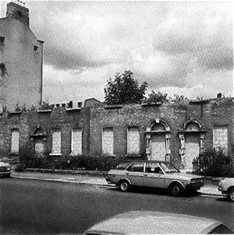 an old brick building with cars parked in front