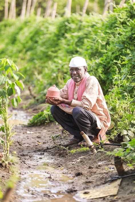 Premium Photo | Indian farming happy farmer holding piggy bank in farm ...