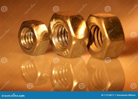 Three gold nuts. stock image. Image of hardware, nuts - 11214017