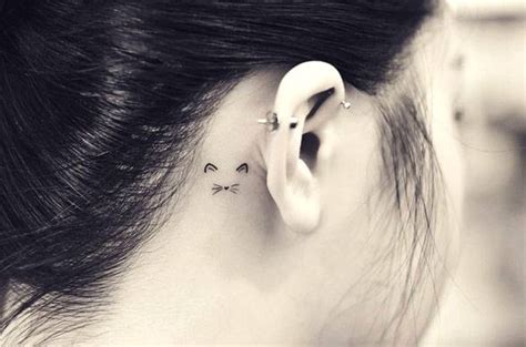 Minimalist cat tattoo behind the right ear.