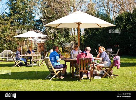 People chatting, drinking and eating in a pub garden in the spring ...