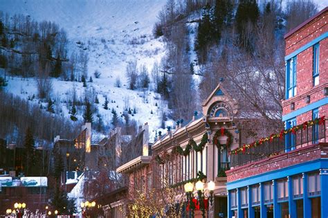 a city street with buildings and christmas decorations on the trees in ...