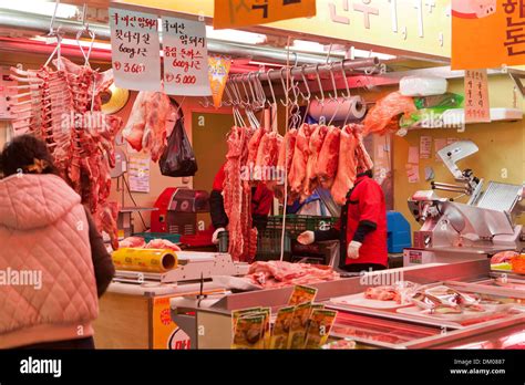 Cuts of meat hanging on hooks at a traditional market butcher shop ...