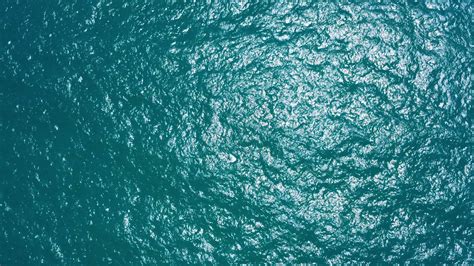 Aerial view of sea waves crashing on rocks cliff in the blue ocean. Top ...