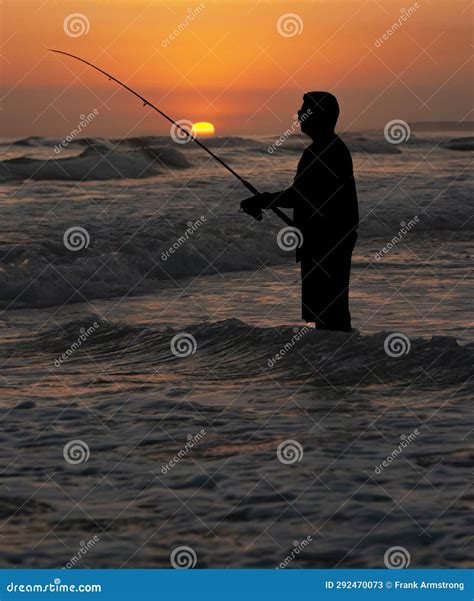 Silhouette of a Man Surf Fishing at Sunset with the Sun Visible Stock ...