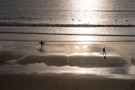 Premium Photo | Landscape of a spanish beach at sunset with surfers ...