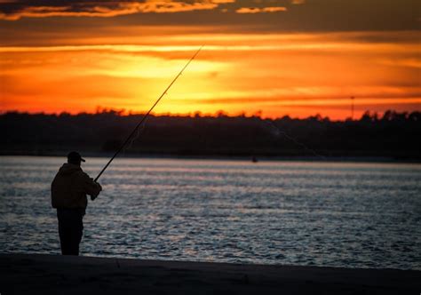 Premium Photo | Silhouette man fishing in sea against sunset sky