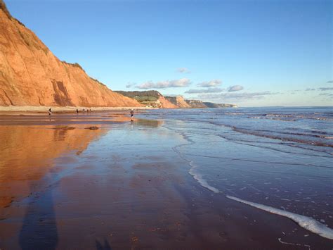 Red cliffs reflecting on the wet sand at low tide. Sidmouth | East ...