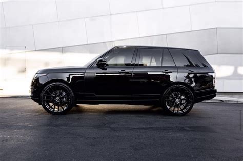 a black range rover parked in front of a white building with chrome ...