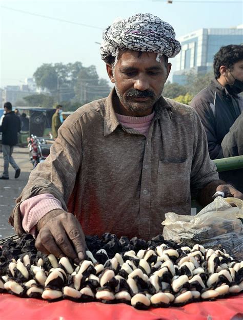 A street vendor selling boiled water chestnut (Singhara) on his bicycle ...