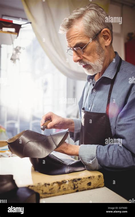 Profile view of cobbler making a shoe Stock Photo - Alamy