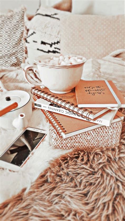 a bed topped with lots of books next to a bowl filled with food on top ...