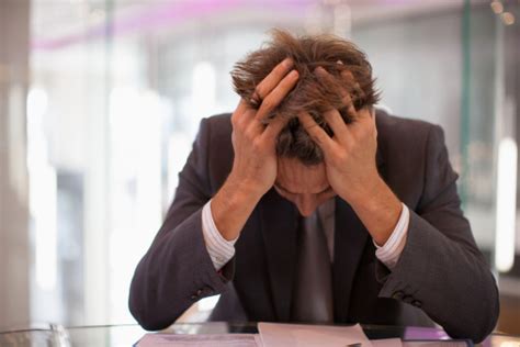 Frustrated Businessman Sitting At Desk With Head In Hands Stock Photo ...