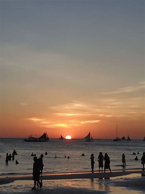 many people are on the beach at sunset