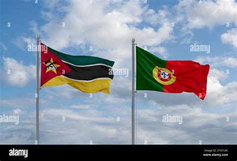 Portugal and Mozambique flags waving together in the wind on blue ...