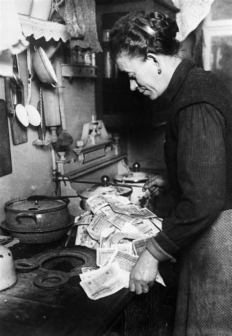 A woman uses banknotes to light her stove. 1923. | German history ...