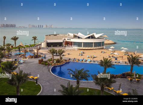 Qatar, Doha, West Bay, Beach and swimming pool of Hilton Hotel Stock ...