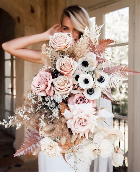 a woman holding a bouquet of flowers in her hands