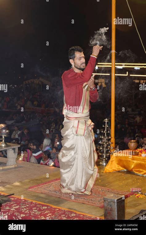 Priest celebrating the river Ganges Aarti by offering incense ...