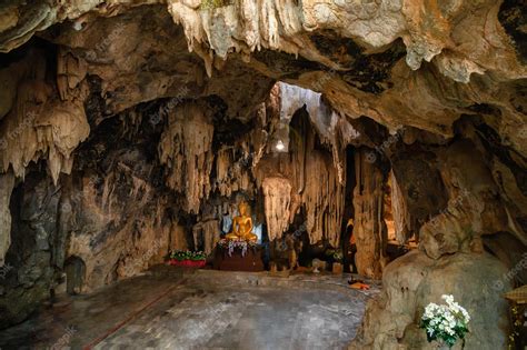 Premium Photo | Stalactite limestone cave with buddha statue