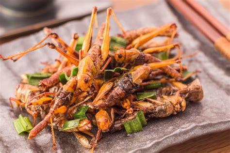 a pile of fried food sitting on top of a wooden table next to chopsticks