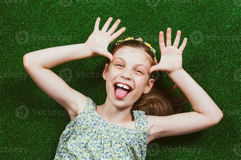 Little girl is lying on artificial grass 23910093 Stock Photo at Vecteezy