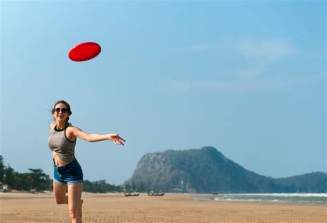 Premium Photo | A woman is playing frisbee at the beach