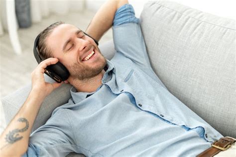 A guy resting on the couch stock image. Image of attractive - 209910239