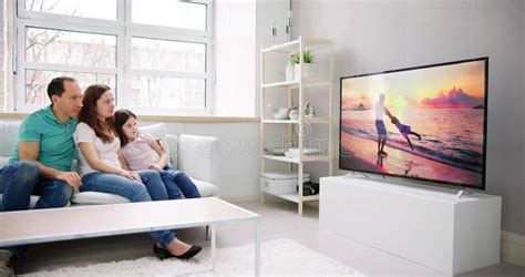 Young Family Watching TV Together Stock Image - Image of women ...