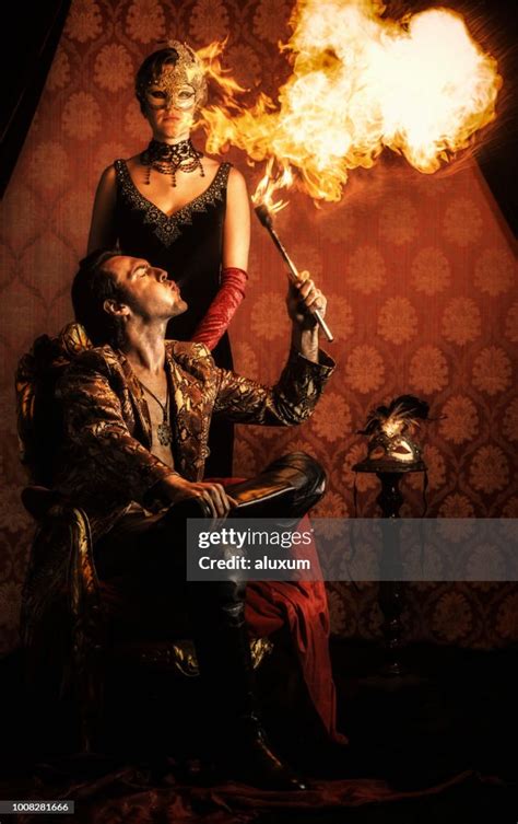 Man Spitting Fire With Mysterious Woman Wearing A Venetian Mask High ...