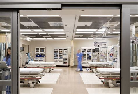 Two emergency department technicians work in a room with four beds ...