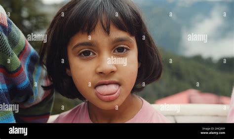 Portrait of a cute Indian girl with a short haircut and bangs showing ...