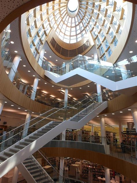 the inside of a library with many bookshelves and stairs leading up to it